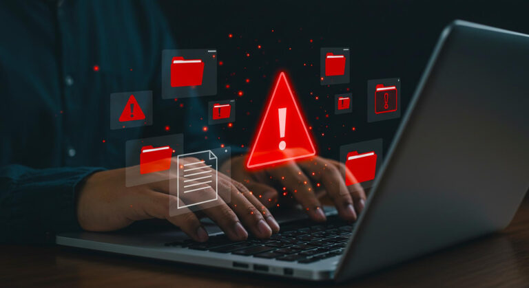 Protezione da phishing, immagine di mani che digitano su laptop con icona pericolo e cartella rosse in sovrimpressione